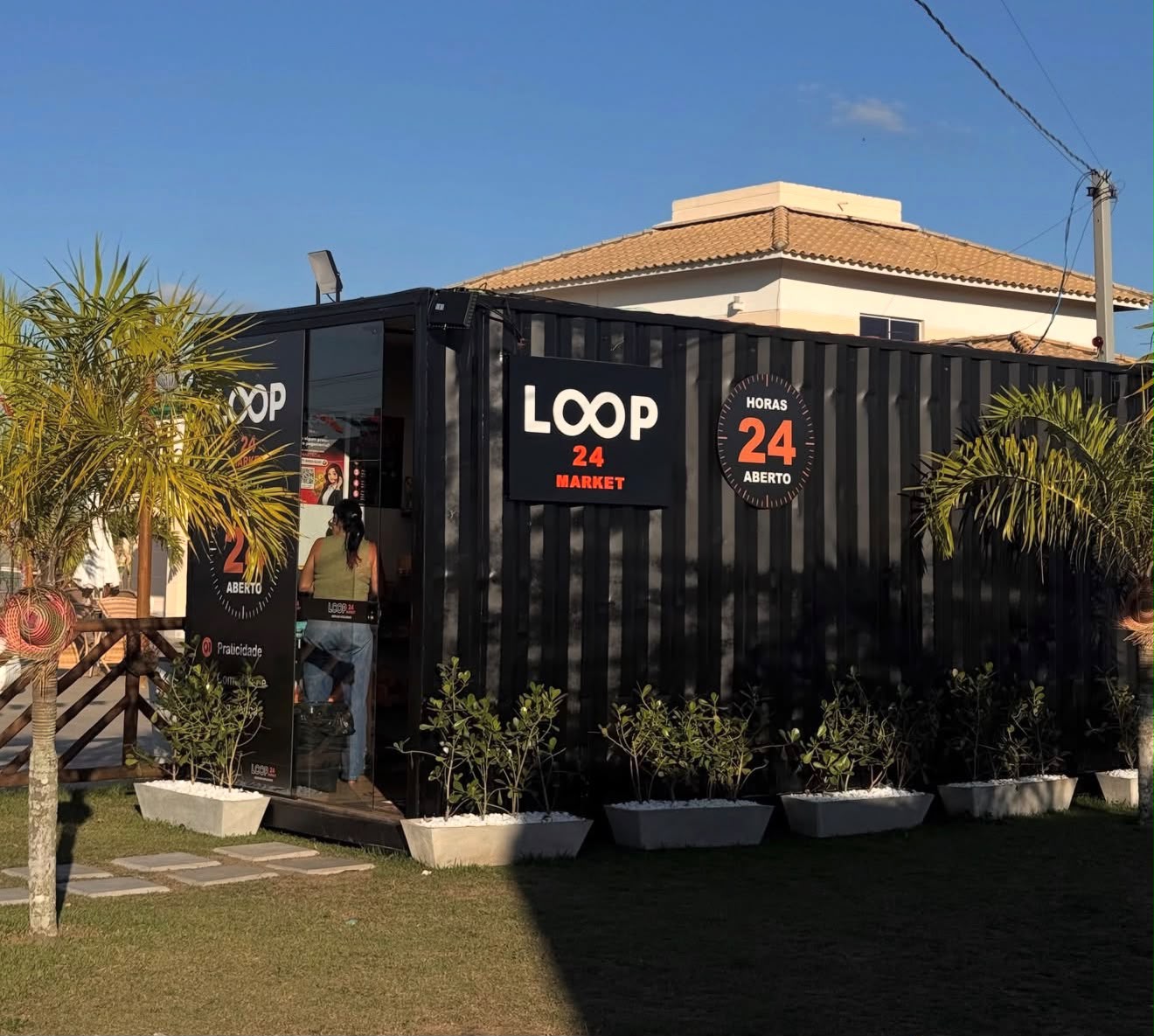 Loja Loop 24 Market em container preto com fachada iluminada